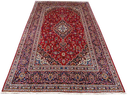 Red carpet with central medallion and multicolored border; even edge finish