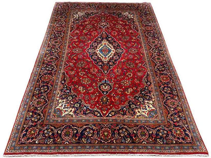 Red oriental rug with a central medallion and surrounding ornamental border