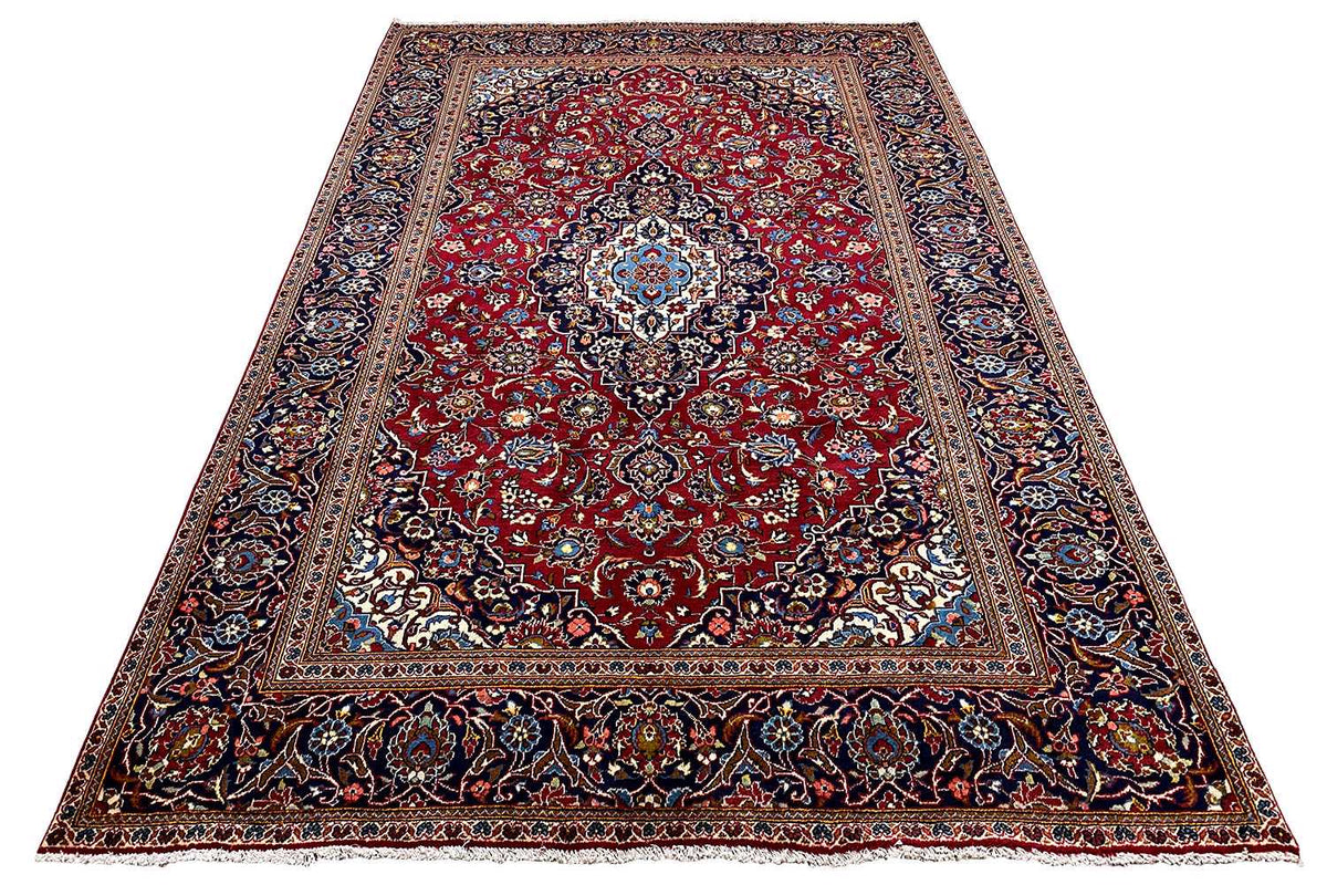 Red rug with a central ornament, dark border pattern, and blue accents
