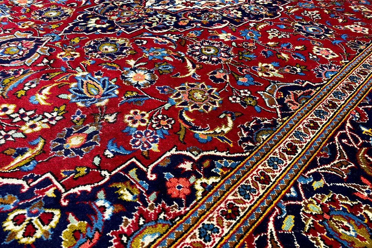 Carpet detail with a bold pattern in blue, red and yellow, as well as a colorful border edge