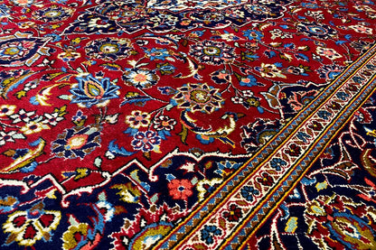Carpet detail with a bold pattern in blue, red and yellow, as well as a colorful border edge