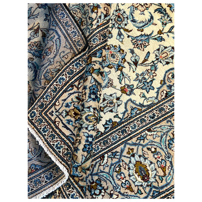 Ornamental rug with a floral pattern, cream-colored background, and blue borders
