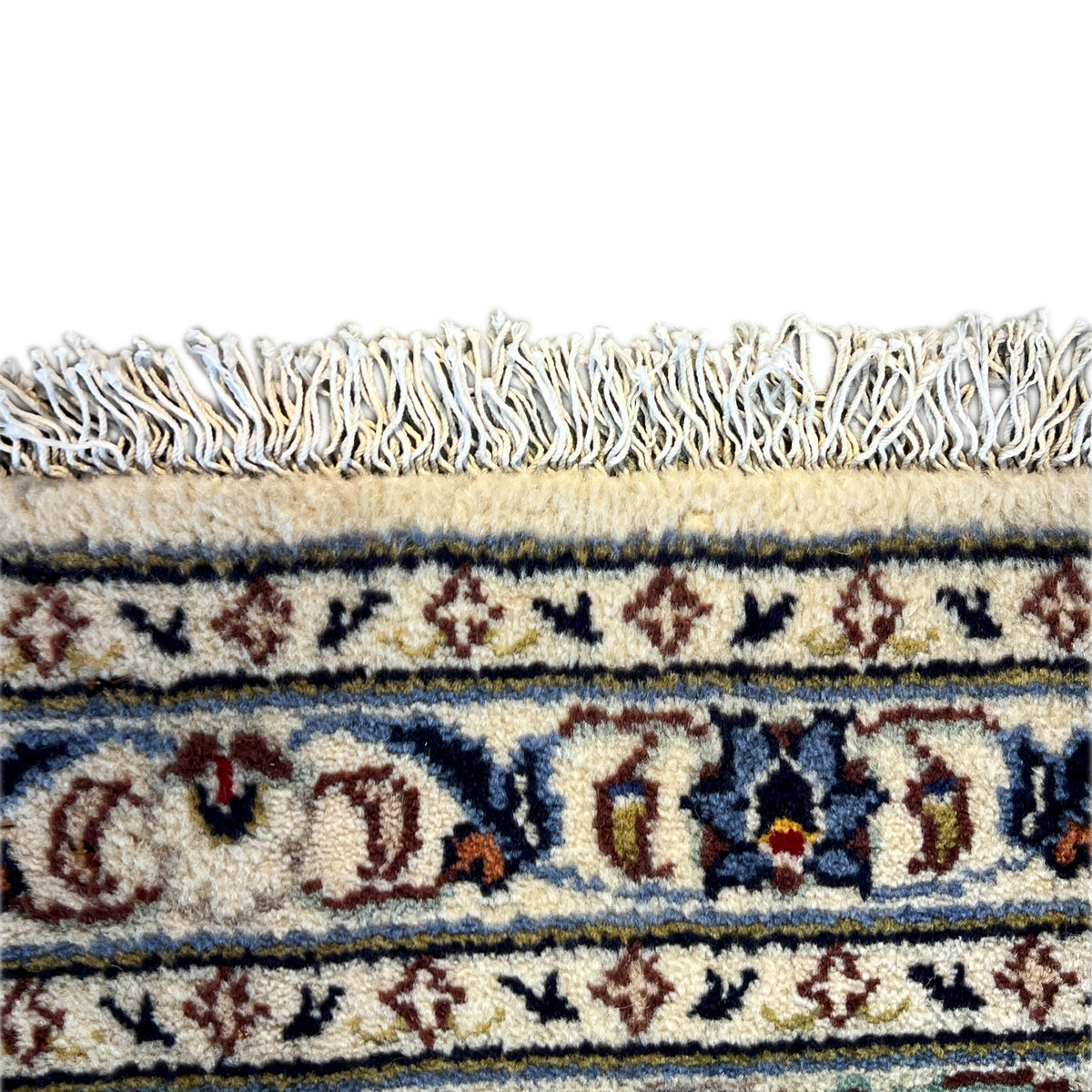 Close-up of a Keshan rug: fringe and colorful border with fine ornaments