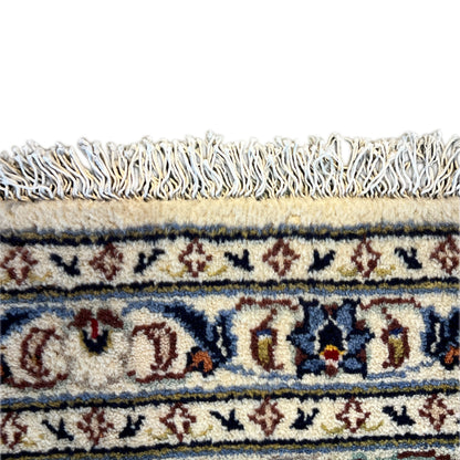 Close-up of a Keshan rug: fringe and colorful border with fine ornaments