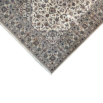 Keshan rug corner: beige ornamental field with a blue decorative border and fringes