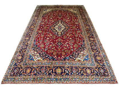 Rechteckiger Orientteppich mit rotem Grund, blauem Rand und Mittelmedaillon