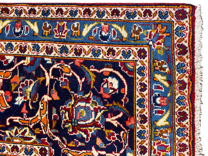 Detail des Orientteppichs: bunte Motive, blau-rote Einfassung und helles Fransenende