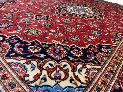 Nahaufnahme der Teppichoberfläche: rotes Feld mit blau-goldenen Ornamenten