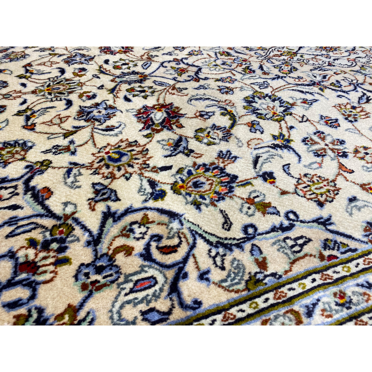 Close-up of the floral pattern: cream-colored background with blue, red, and golden accents
