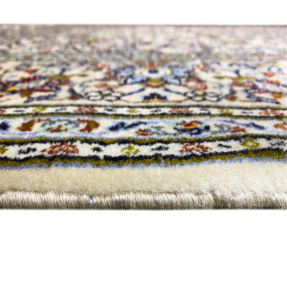 Detail at the edge of the rug: cream-colored pile with a multicolored border and fringes
