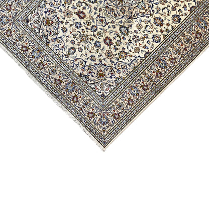 Close-up of a Keshan rug: cream-colored background, delicate multicolored blue border