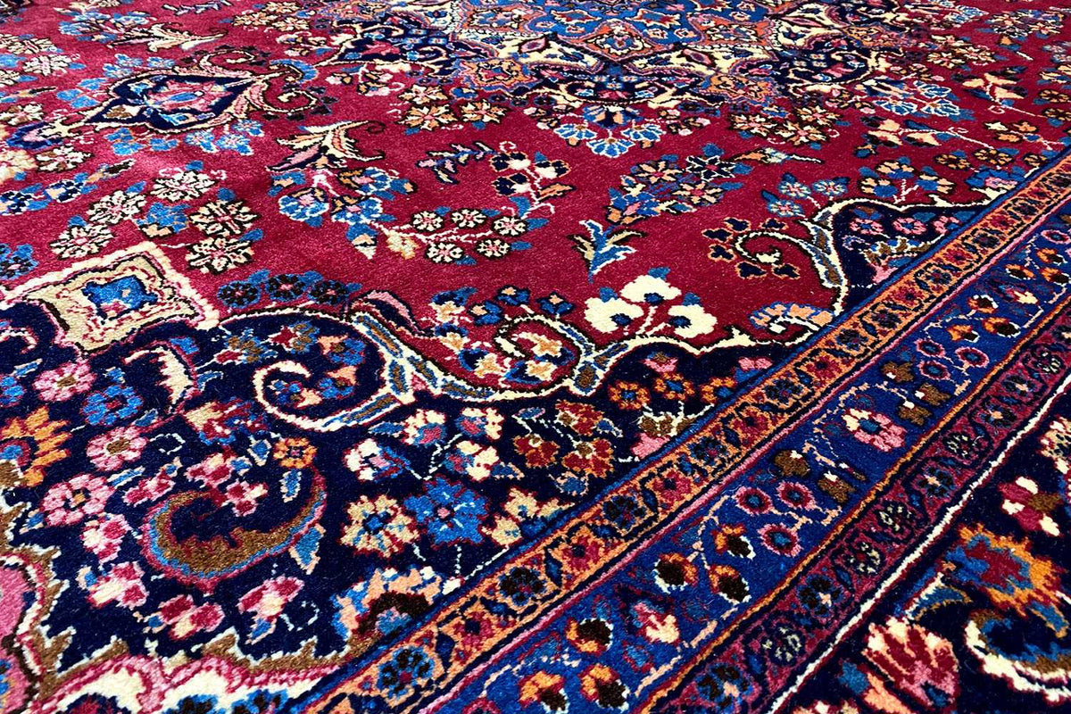 Close-up of an oriental rug: blue field, red medallion, and ornaments
