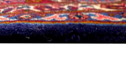 Close-up of a Khorasan oriental rug: rug edge with dark pile and a colorful border