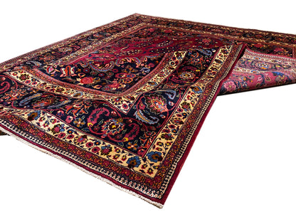 Teppich in Dunkelrot mit blauem Zentrum, ornamentalem Rahmen und Medaillon