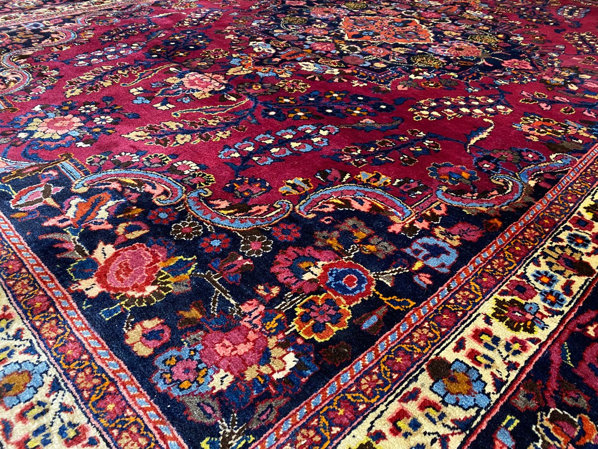 Detailreicher Teppich in Dunkelrot mit bunten floralen Ornamenten und Bordüren