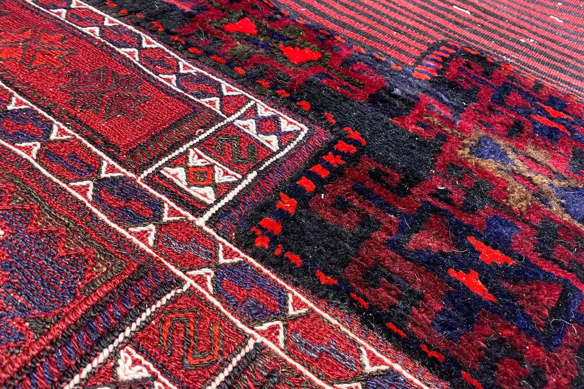 Kilim detail: geometric motifs in red, blue, and black with a white decorative border