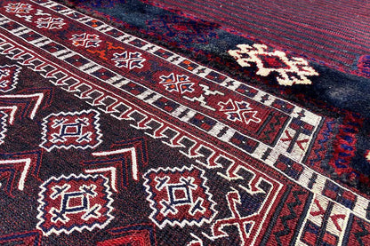 Bakhtiari kilim with a geometric pattern in red, blue, and white on a dark background