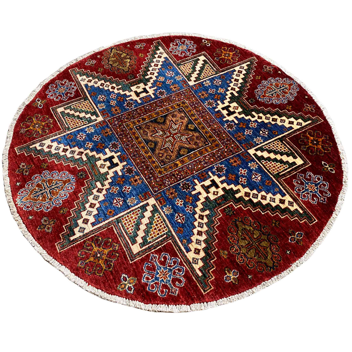 Round wool rug with a red background and blue zigzag and cross pattern, white border