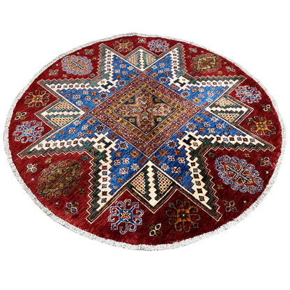 Round wool rug with a blue central star, reddish-brown ornamental border, and white edging