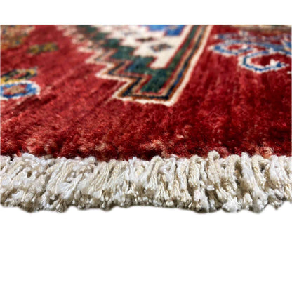 Close-up: soft wool rug with a white fringed edge along the bottom finish