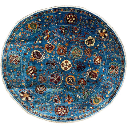 Round wool rug, blue, with a colorful ornamental pattern and a light contrasting border