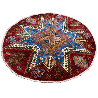 Round rug with a red background and blue central symbol in a patchwork ornament
