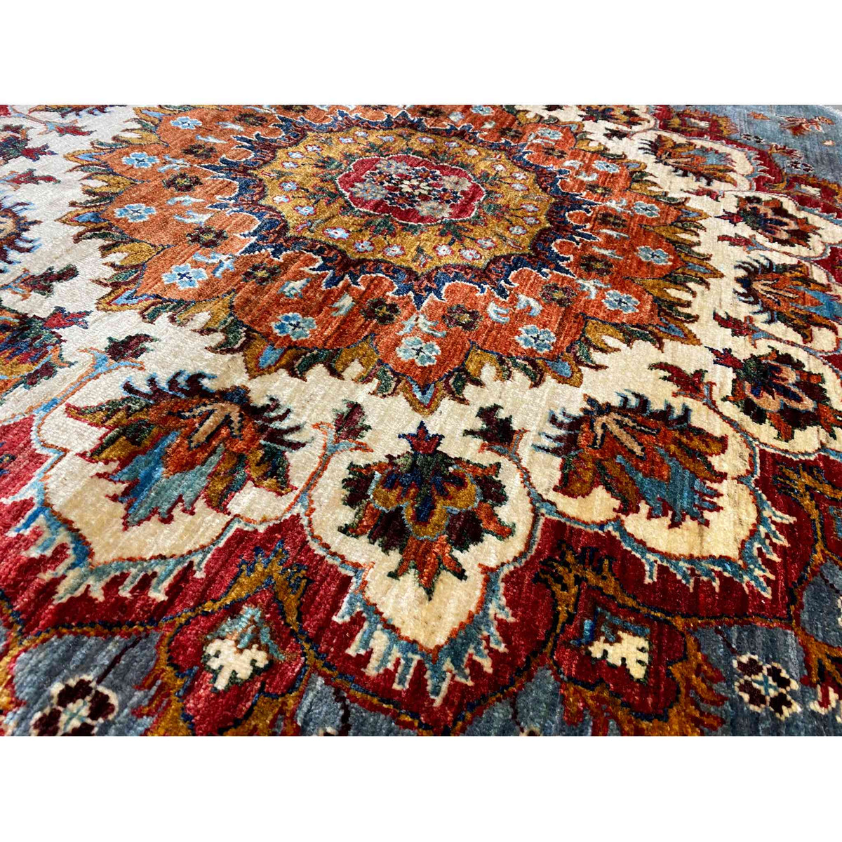 Carpet pattern in detail: cream base with red, blue, and orange ornaments