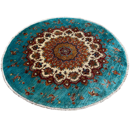 Circular turquoise Khorjin rug with vintage ornaments, a border, and decorative motifs.