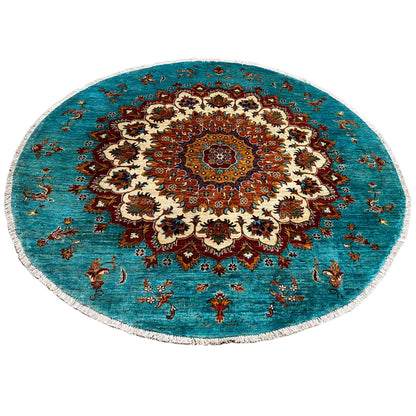 Round Khorjin rug: turquoise background with a detailed ornamental vignette in red, cream, and brown.