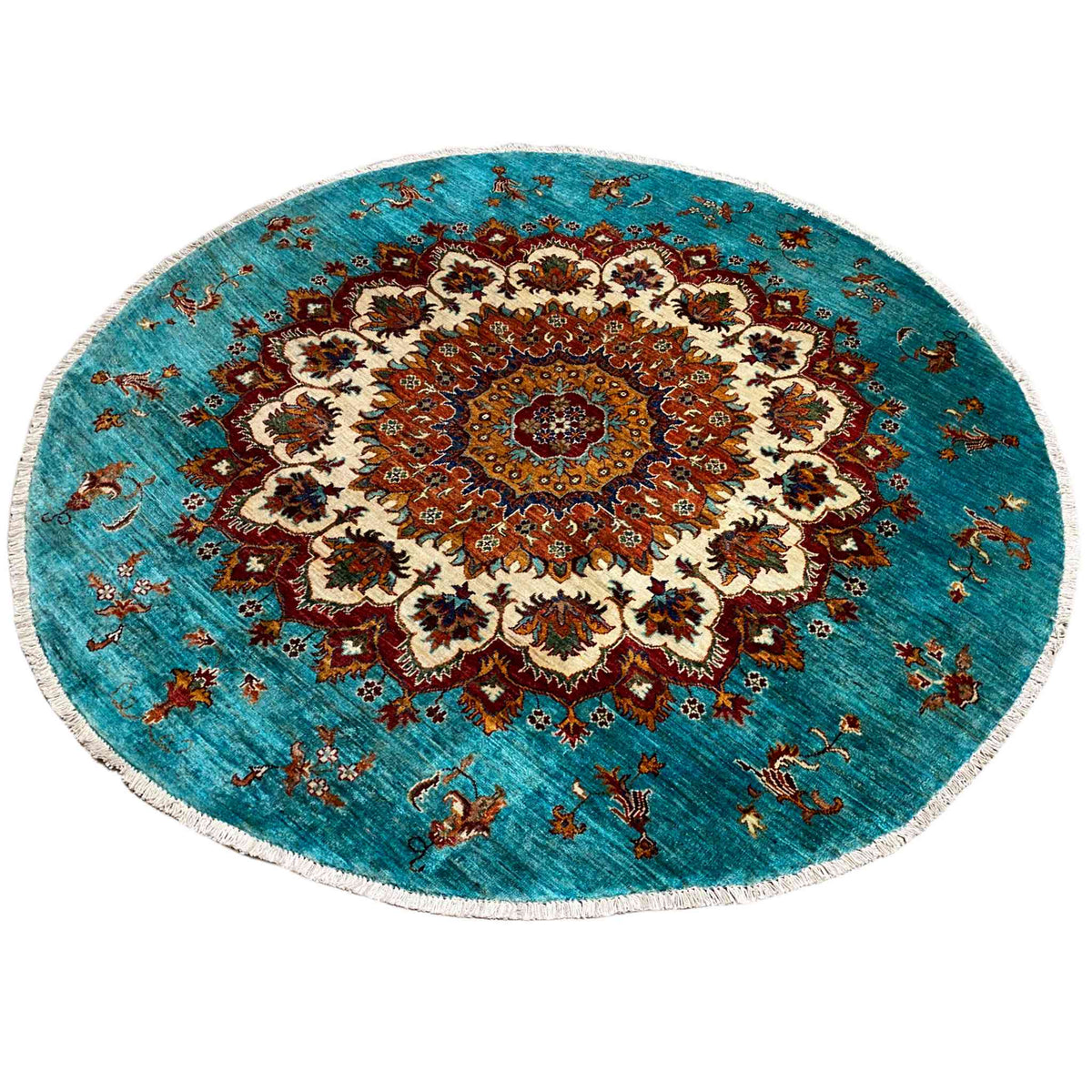 Round rug in Khorjin design in turquoise and red with a large decorative medallion and fringed edge.