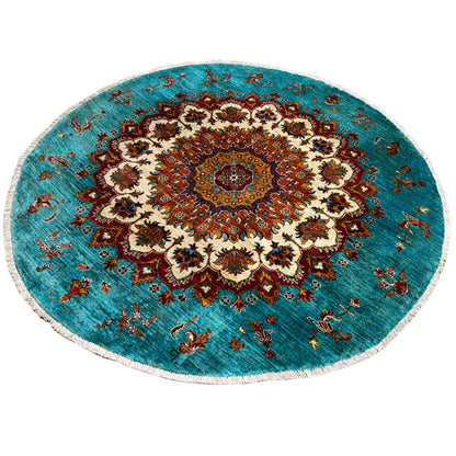 Round rug in Khorjin design in turquoise and red with a large decorative medallion and fringed edge.