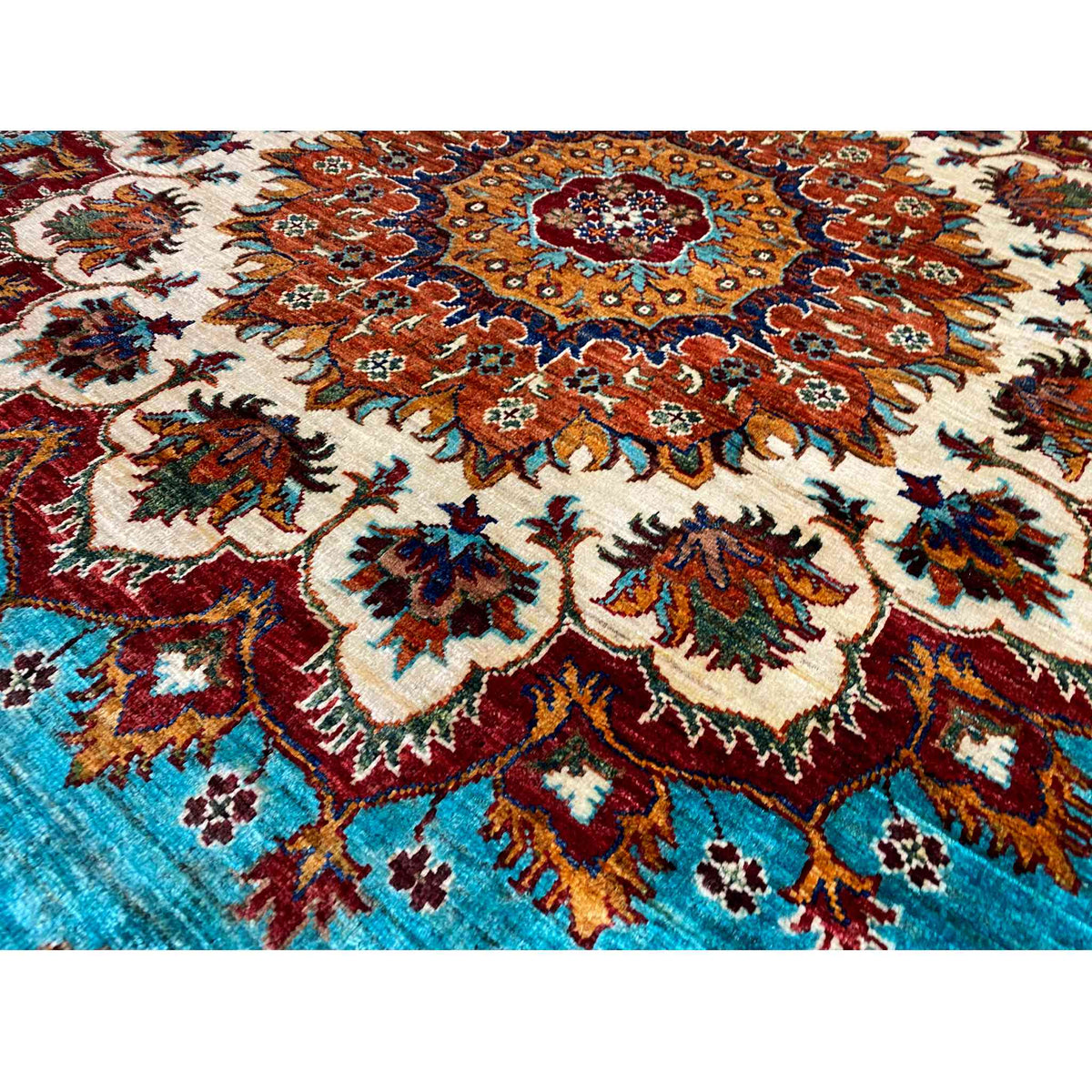 Detailed view of the carpet pattern: turquoise field with red, brown, and cream-colored ornament.
