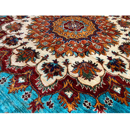 Detailed view of the carpet pattern: turquoise field with red, brown, and cream-colored ornament.