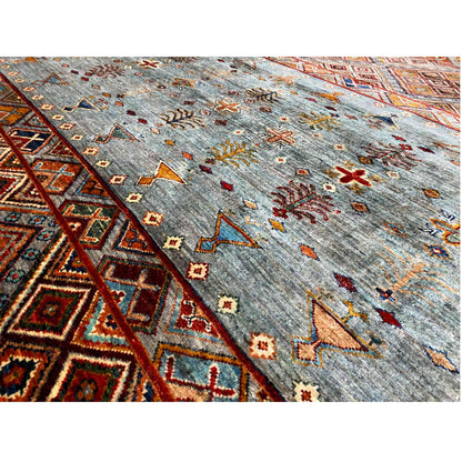 Close-up: gray-blue wool rug with colorful crosses and ornaments, rectangular border