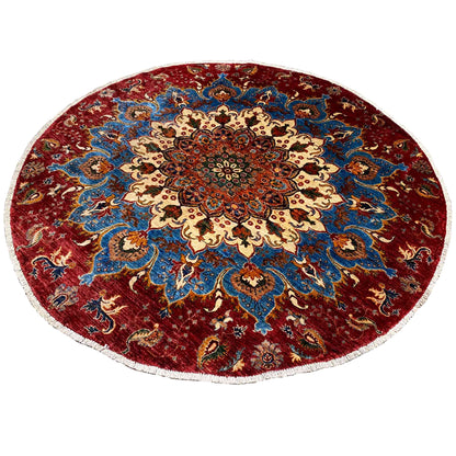 Round wool rug with a red background, blue vine pattern, and central medallion flower