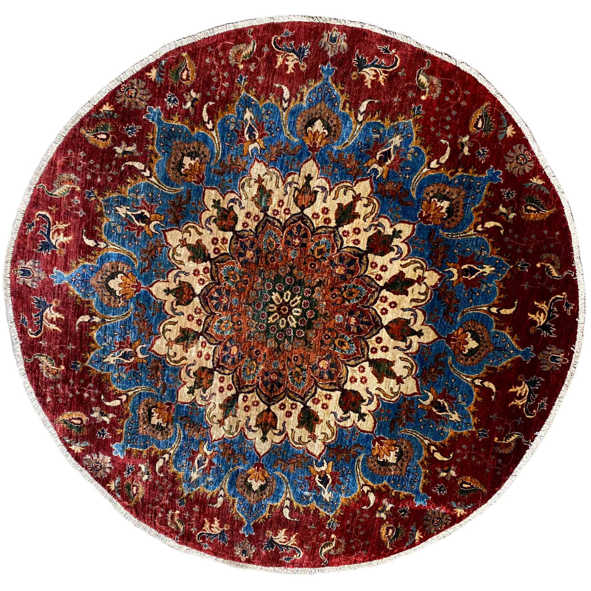 Round wool rug with a red and blue ornamental pattern, cream-colored details