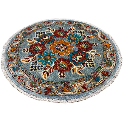 Khorjin round wool rug: bold floral pattern in blue, red, and green with border