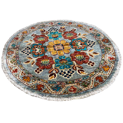 Round wool rug with a blue background and colorful floral ornaments
