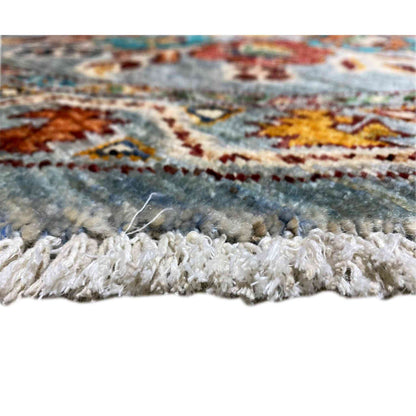 Close-up of rug edge with fringe and blue pattern, multicolored accents