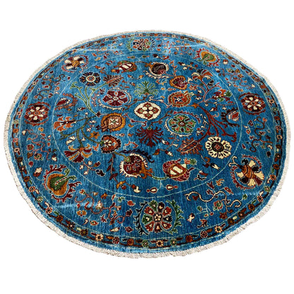 Round blue wool rug with a vibrant floral pattern and intricately detailed border