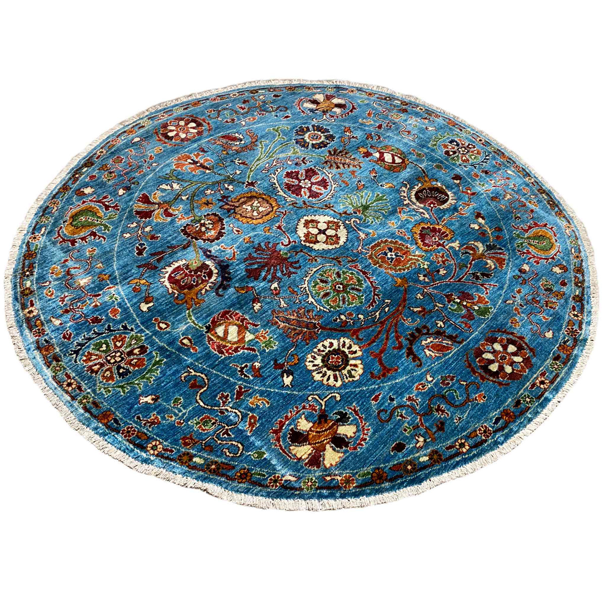 Blue round wool rug with a multicolored floral motif and curved patterned border