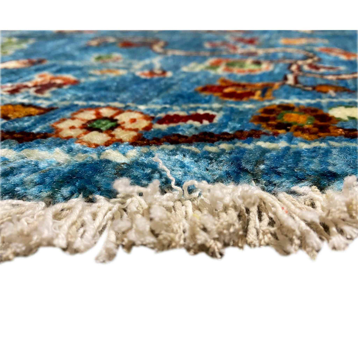View of the rug edge: short wool pile with fringe along the bottom edge