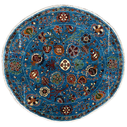 Round blue wool rug with a colorful floral and ornamental pattern and border trim