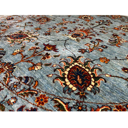 Close-up of a hand-knotted Khorjin rug: blue-gray field with a red and gold medallion