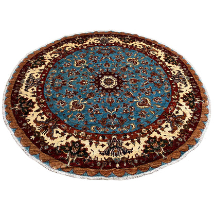 Round wool rug with a blue patterned center and dark ornamental border in beige