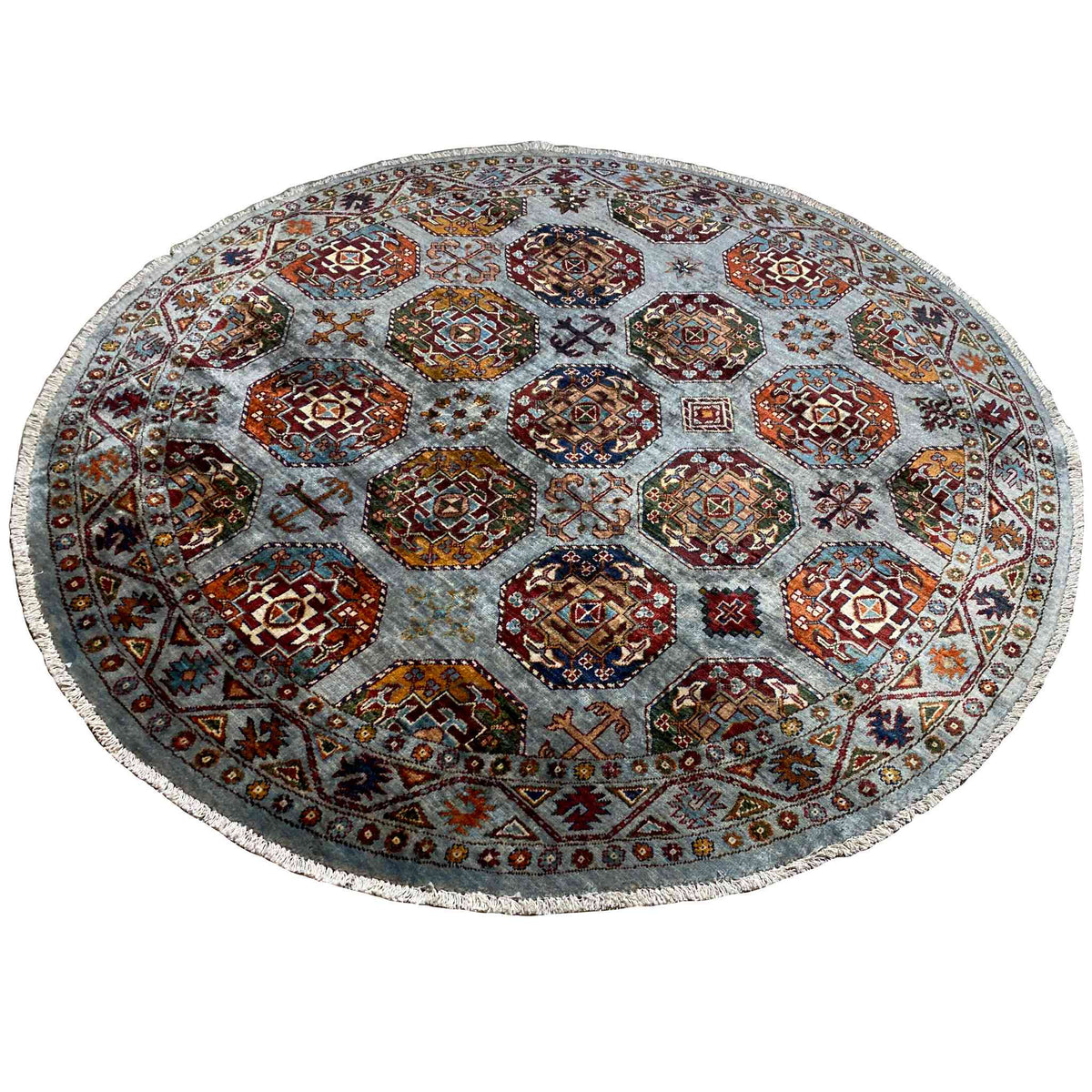 Round rug: geometric hexagon patterns in orange, red, and blue on a light gray background