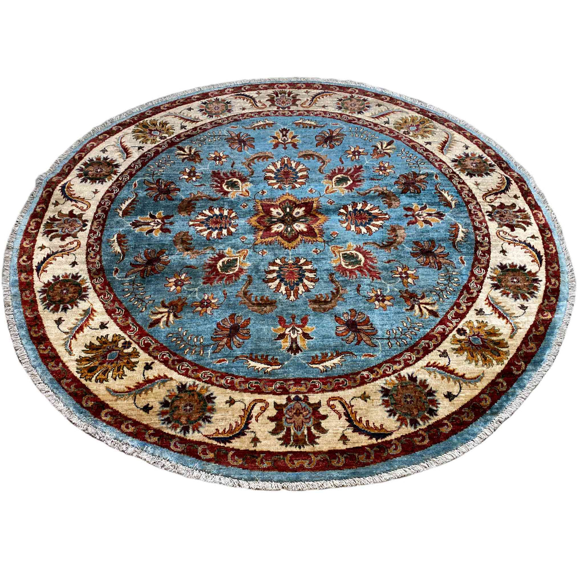 Round rug with a blue floral medallion, cream-colored border, and colorful decorative elements