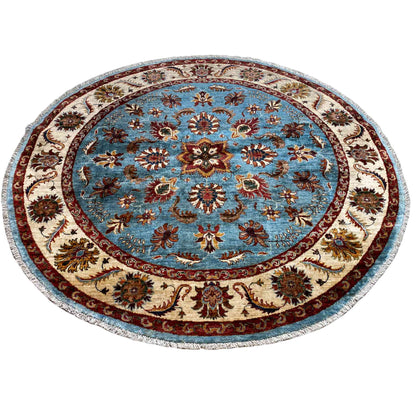 Round rug with a blue floral medallion, cream-colored border, and colorful decorative elements
