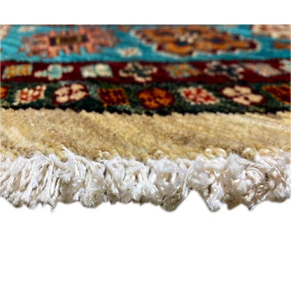 Rug edge with white fringe trim and a colored border along the cream-colored hem