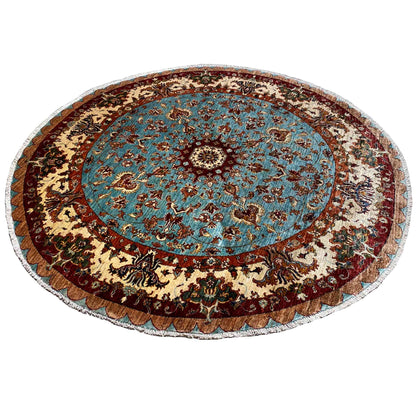 Round rug with a blue central medallion, dark decorative border, and beige ornamental wreath